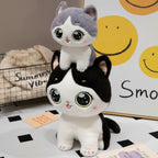 wllio.com black and white cat plush toy with big sparkling eyes, and a grey cat plush toy on top.
